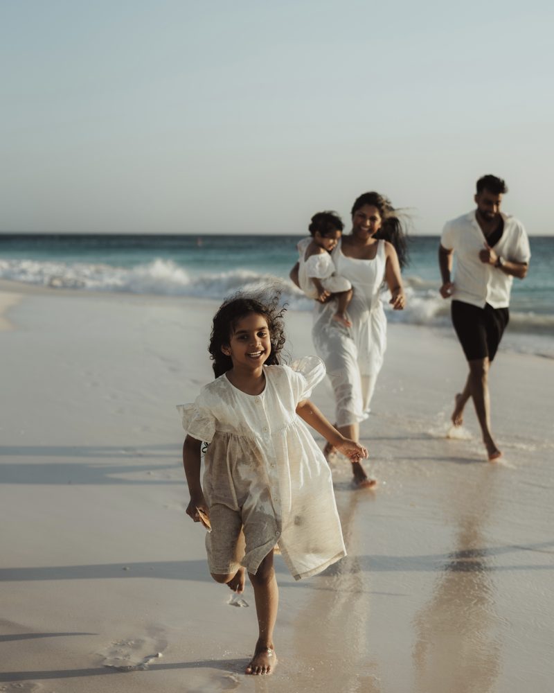 Gezin rent samen over het strand